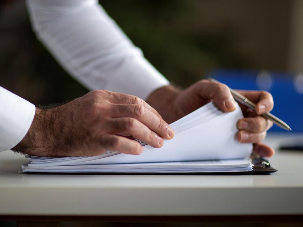 Hände blättern durch eine Akte